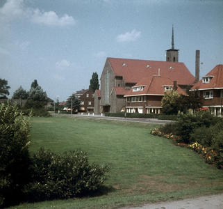 119419 Gezicht op het plantsoen aan de H.F. van Riellaan te Utrecht, met de Tuindorpkerk (H.F. van Riellaan 5a).